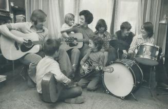 Kees and Maureen Huismans conduct a lively and happy music session in the living-room of the group home they operatate for the Children's Aid Society