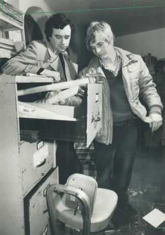 Aftermath of raid: Brian Iler, left, lawyer for the Cruise Missile Conversion Project, a group opposed to nuclear weapons, looks through a filling cabinet with project member Andrew Van Velzen, after the police had spent 3 1/2 hours searching the group's Bathurst St