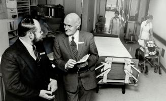 Team work: Chief of psychology at North York General Hospital, Dr. Bud Hoddinott, left, discusses a case with the co-ordinating chaplain, Rev. Samuel Baxter.