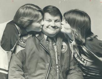 Proud man of the year, Fred Johnson, 44, is kissed by daughters, Carol (left), 14, Cathy, 17