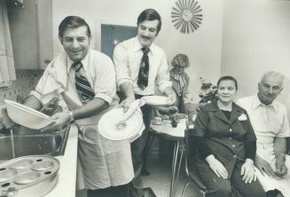 You wash and I'll dry: Toronto Kirjakou and brother Tony do the dishes the way their father Jerry Kiriakon, right, did for years to bring them and their mother, Peggy, seated, from their native Greece