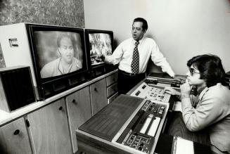 Farooq Khan, chairman of Voice of Asia, watches tape editing machine with son, Rimmel