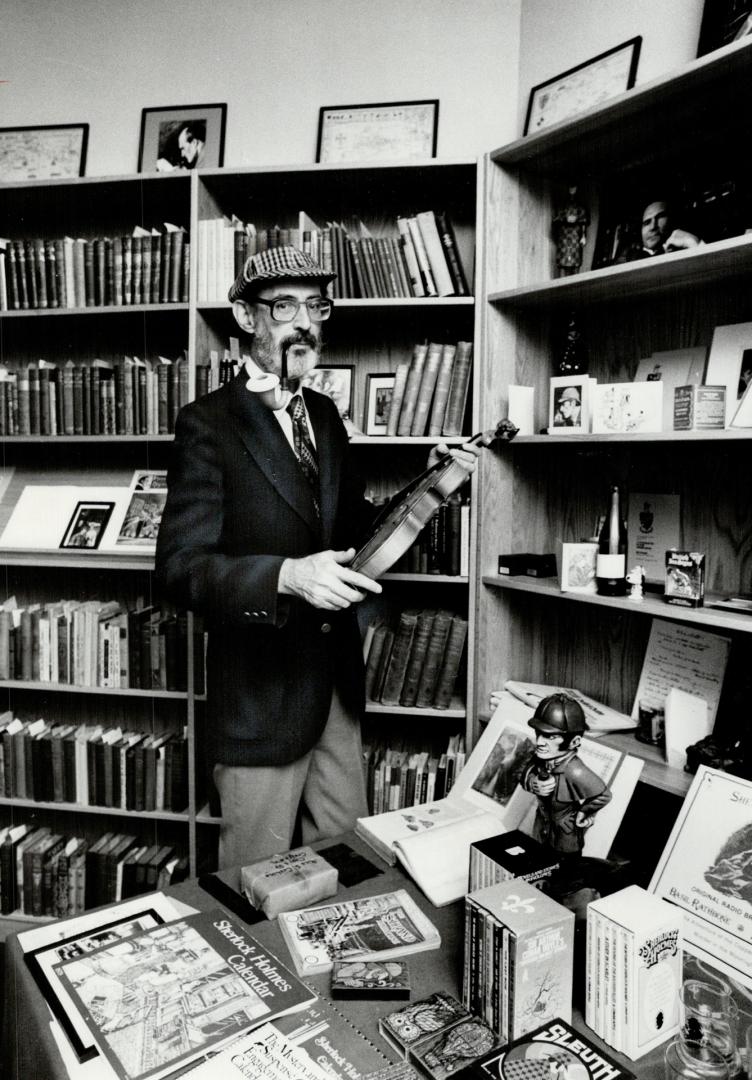 A bearded man in a deerstalker hat with a pipe holds a violin in front of books and collectable…