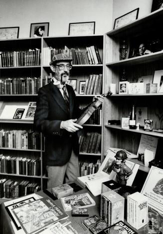 A bearded man in a deerstalker hat with a pipe holds a violin in front of books and collectable ...
