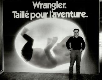 Controversial Ad: Ihor Holubizky, assistant curator of Harborfront Art Gallery, poses with a billboard for Wrangler Jens that caused a stir when it first appeared in France