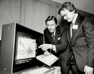 Farming with computers: William Hutchinson, infomart president, shows the Grassroots system to Maury Miller, a vice-president of CENEX, one of Infomart's U