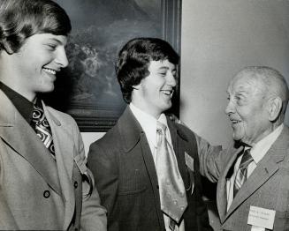 Bearing famous names, Gerry Sawchuk (left), son of great goalie Terry Sawchuk, and Kim Jackson, whose father was legendary busher Jackson, talk with Cyclone Taylor during Hockey Hall of Fame ceremonies at CNE yesterday