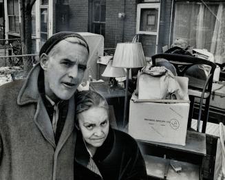 Evicted form their home, Albert and Eva Jones stand in front of their possessions, piled on the sidewalk yesterday by two men who carried them out of house while Mrs