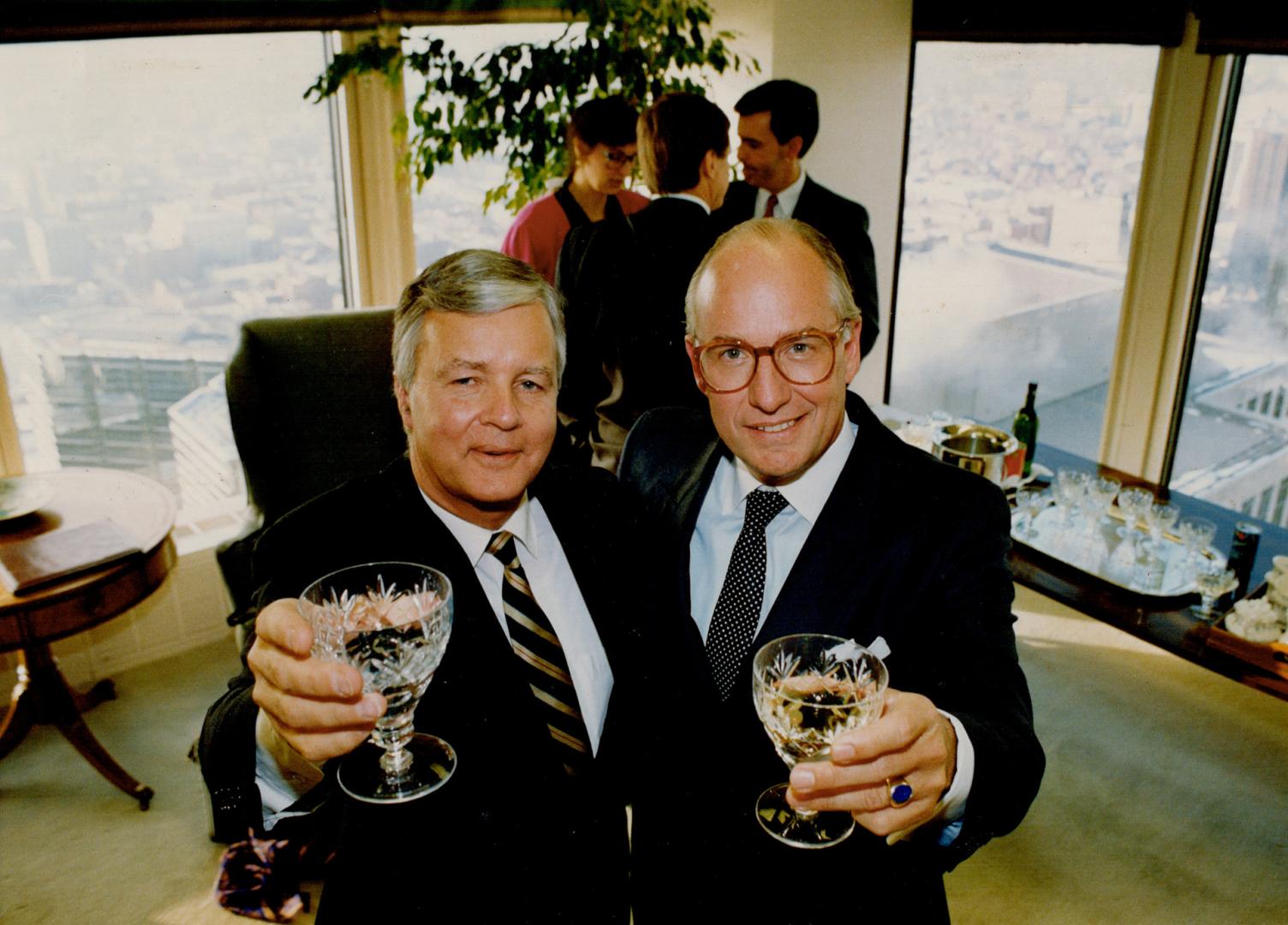 Edmund King, left, Wood Gundy chairman, and Michael Sanderson, Merrill Lynch president, toast deal that sees Gundy acquire Merrill's retail business.