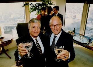 Edmund King, left, Wood Gundy chairman, and Michael Sanderson, Merrill Lynch president, toast deal that sees Gundy acquire Merrill's retail business.