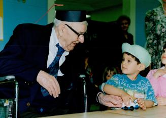Across the ages: Bill King, who's 100 years young, shares a smile with a youngster in a play-school run by Grade 12 students learning about child care