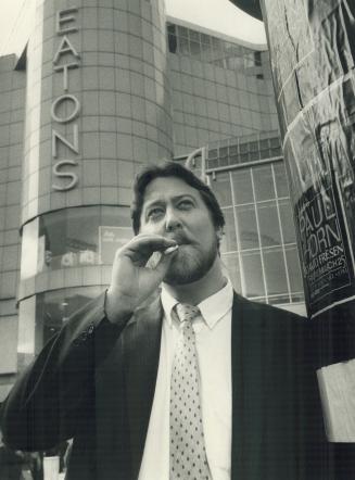 Still puffing: Graham Lance, a 28-year-old computer analyst, enjoys a cigarette outside the Eaton Centre today after refusing to butt out on the job