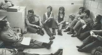 Taking a study session, Professor John Lee, in striped shirt, Jeans against filing cabinet as he makes a point to students at the University of Toronto's Scarborough College