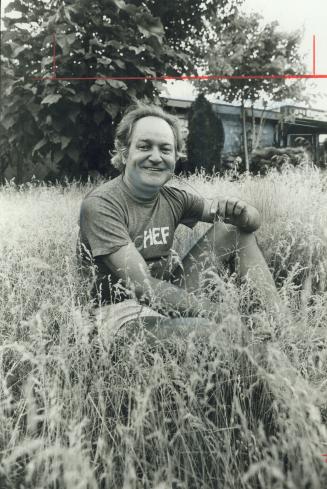 Architect Istvan Lendvay sits on don Mills lawn he hasn't mowed since May - it's a protest against neighbors who let their dogs use lawn as a bathroom