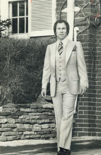 Cyril Levenstein, company president, models a pastel melon vested suit created for wearing this spring.