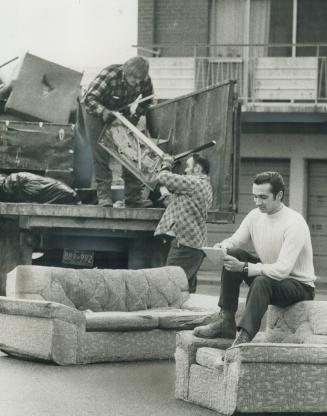 Sitting on the Garbage, Robert Litz, a private contractor hired by the borough of Etobicoke to collect and dispose of bulky items, takes notes as worker loads furniture on truck