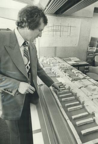 City Planner Alan Lit looks over a model of the St