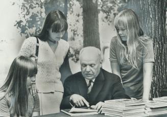 The director of the National Museum of Poland, Dr. Stanislaw Lorentz, shows pictures of the centuries old royal palace in Warsaw to (from the left) Joanne Glista, 11, Bozena Cicha, 15, and Caroline Glista, 12. The Glistas live in Mississauga: Bozena is visiting from Poland. Lorentz will rebuild the bombed palace.