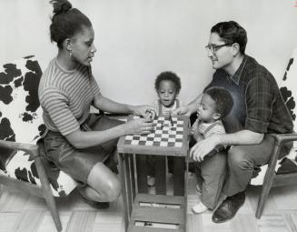 Twins Julian and Timb Kosloff referee a family game of chess in the Kosloffs' aparment in the public housing development in Flemington Park