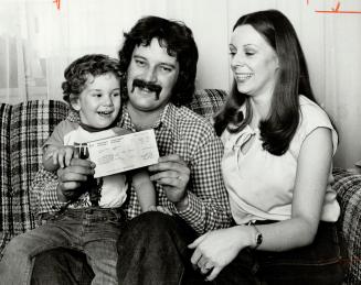 William Laxton of Mississauga, his wife, Doris, and son, Jason, 3, look at refund cheque that claims Laxton is dead