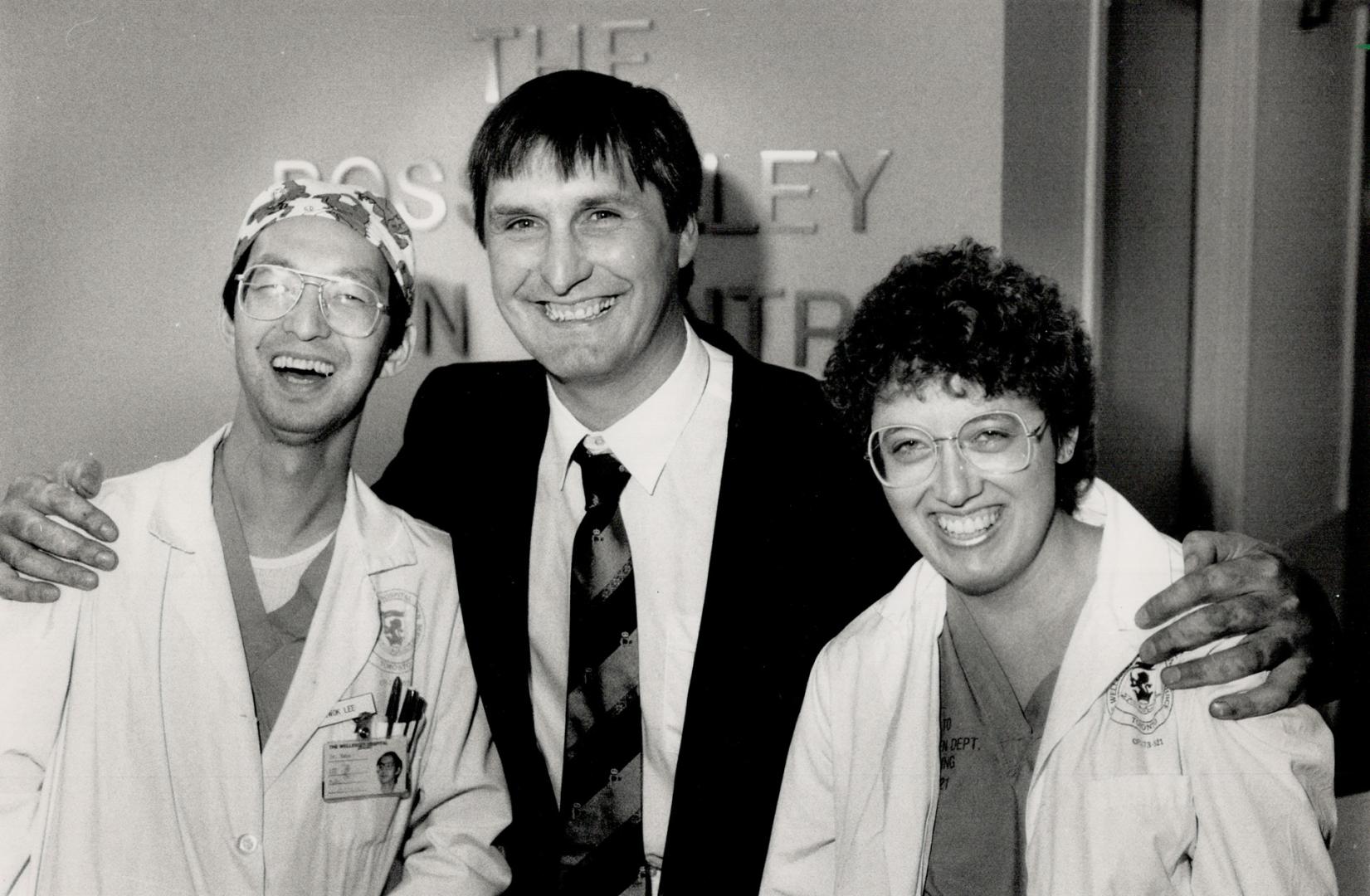 Grateful patient: Guest of honor at the unveiling of Wellesley Hospital's burn unit donor wall, Martin DeGroot hugs Dr. Kwok Lee and nurse Sally Fay. They helped him recover from burns that at first were expected to prove fatal.
