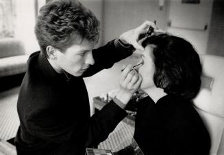 Eye spy: Makeup artist Michel Limongi shows a client how to co-ordinate her mascara and eyeshadow with her dress color.
