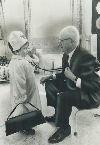 Senator Frederic McGrand, a doctor for 40 years and former minister of health and social services for New Brunswick, gets a pretend heart check-up by James Warren at Duke of York Public School