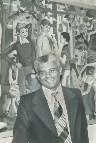 Social worker Brian McPherson stands, appropriately, in front of a mural showing children at play