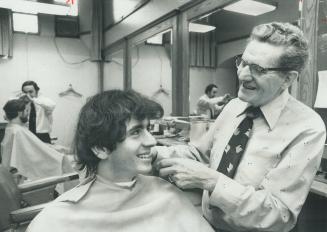 Barber at Hart house for 41 years, Roy Mahood chuckles over his experiences while cutting the hair of engineering student Thomas Jelinowicz yesterday