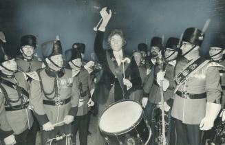 Clothier Cy Mann, centre, went outside ot march with the Toronto Signal Corps brass band during one of champagen parties which marked the opening of his new store in the Four Seasons-Sheraton Hotel