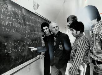 Raymond McAfee (second from left) discusses a point at the black-board with some of his community college students