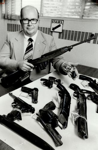 Gun registrar Derek McBrien displays surrended guns