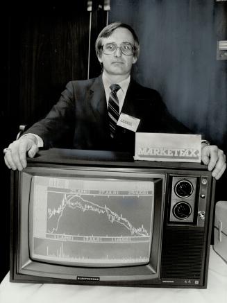 Stars of the screen: John McLauchlan stands over a television screen displaying his company's stock market information system