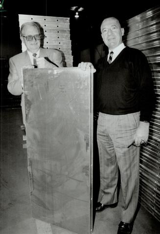 Export bound: Bill Malone, left, who designed a reusable aluminum form system for concrete construction, displays one of the panels with John Berger, of TS Aluminum, which finished the forms