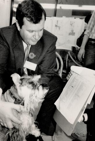 I'll be Doggoned! Lawyer Peter Maloney, running in Toronto's Ward 5, checks the voters' list with a gray schnauzer named Keba and sure enough, the dog is registered to vote