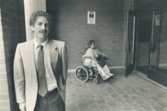 Helping disabled: Jordan Max, acting chairman of the March of Dimes' Accessible Housing Coalition, stands in front of an apartment building at 25 Elm St
