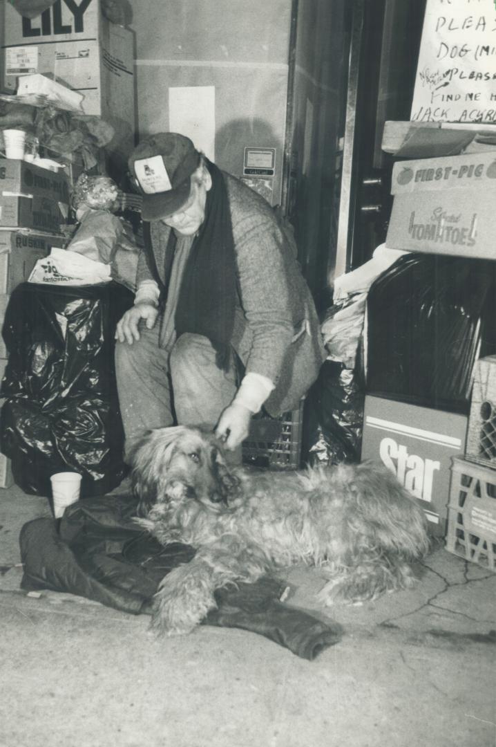 Milk Bone's back: News vendor John Mucenieks pets his dog Milk Bone, returned yesterday after being seized by Toronto Humane Society officials who said he didn't have adequate shelter