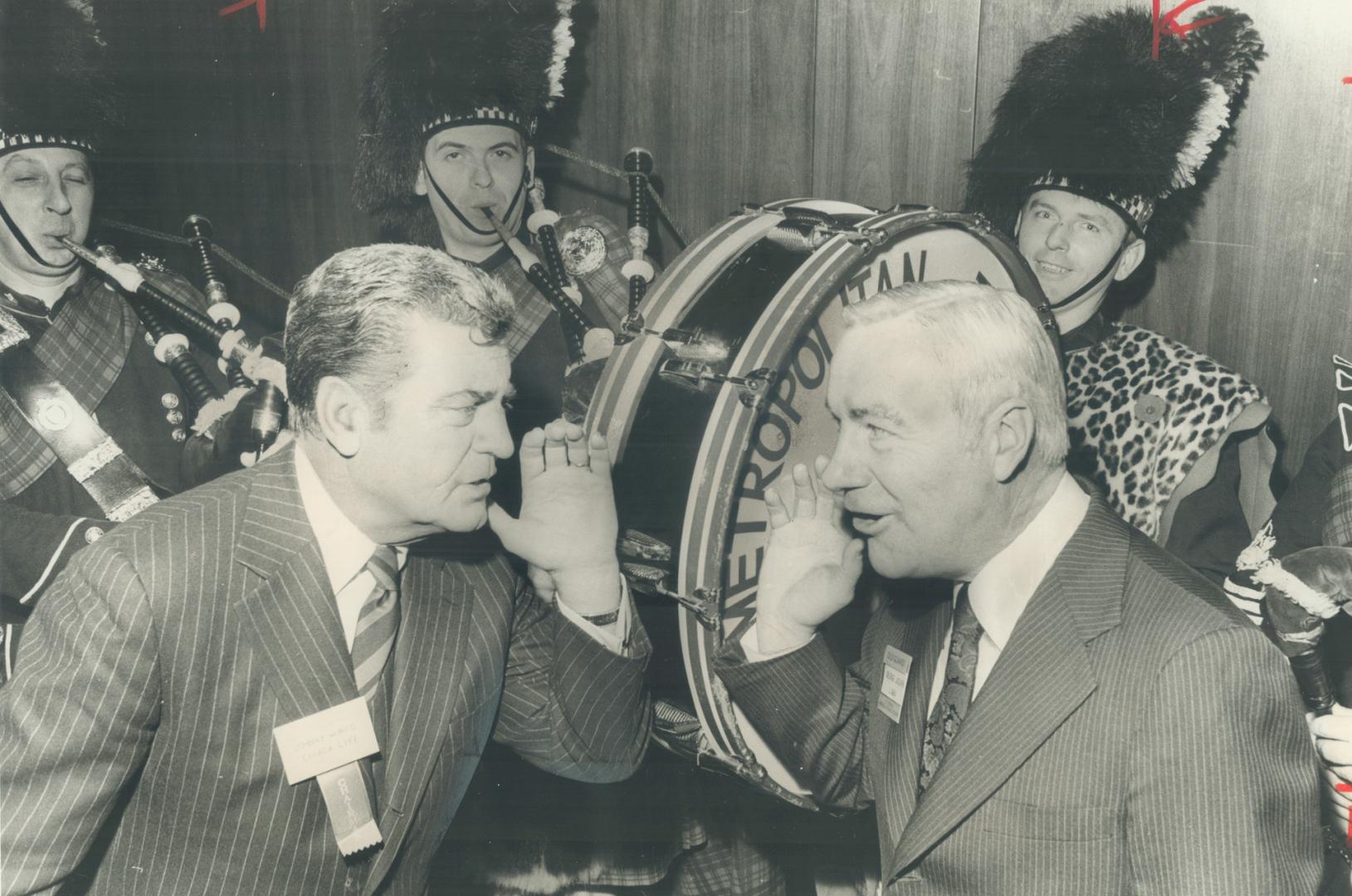 One-time argo halfback and footfball referee Johnny Munro (left) give the go signal to opena convention of life insurance executives yesterday - with the loud help of the loud help of the Metro police pipe band