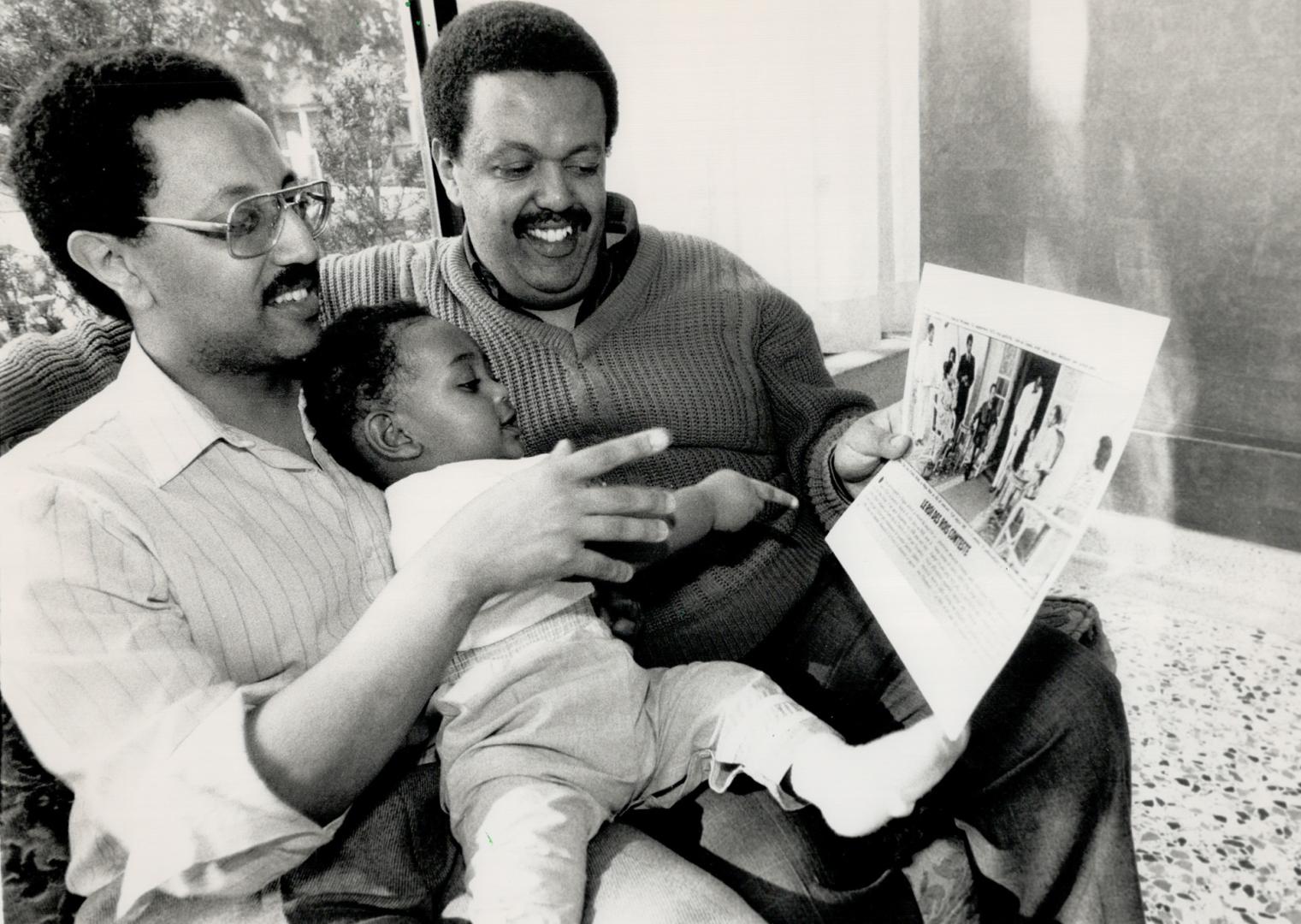 Mother released: Stephen Mengesha, right, his daughter Araya and brother Jalye look at a photo of relatives of theirs with Emperor Haile Selassie of Ethiopia