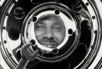 Hot rods: Harold Middleton, 41, a trucker-turned-car-appraiser, peers through the chrome wheel of a '47 Ford called Rock 'n' Roll Flathead
