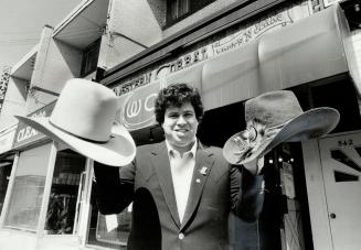 High-riding headgear: Darryl Miller, co-owner of Western Corral Boots N' Jeans, displays an $85 Biltmore hat, left, and an imported custom-made $465 hat with a rattlesnake head on it, right