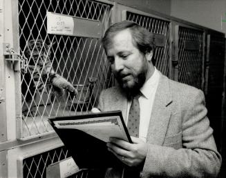 Get me out: A young tabby tries to get the attention of Animal Centre's Don Mitton.