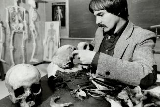 Measuring up: El Molto, a skeletal biologist at Scarborough College, makes some measurements on a skull found in Thunder Bay