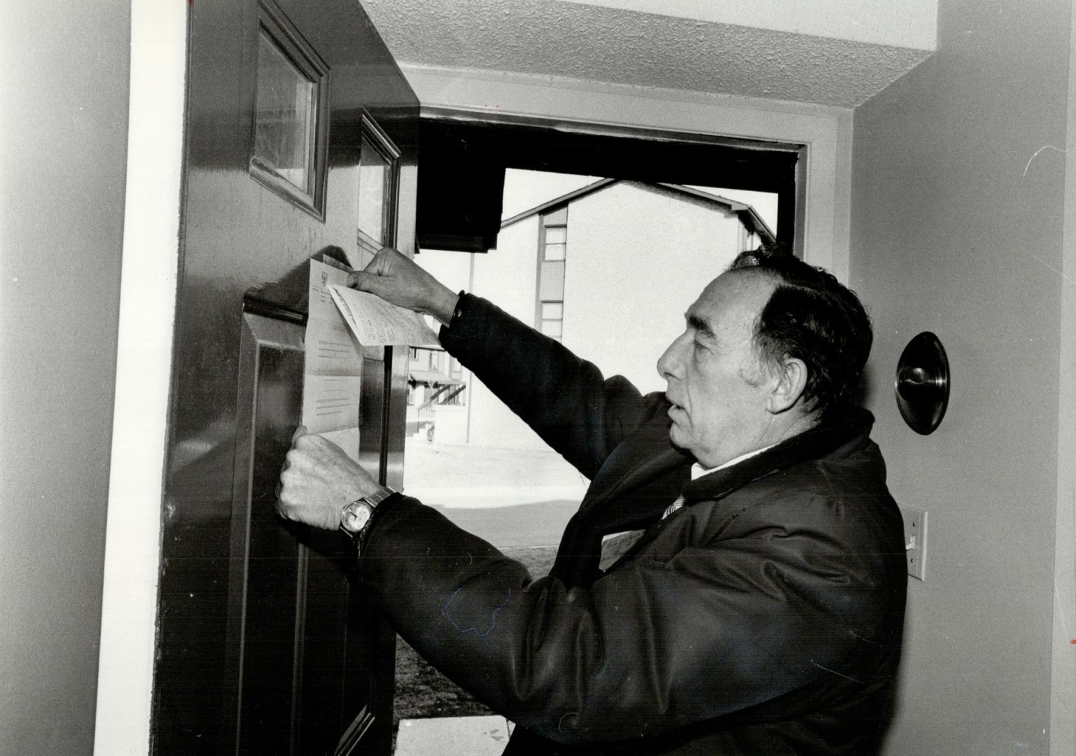 It's final: Sheriff's officer Ross Moore attaches the official notice to the door of a home whose owners were unable to keep to the mortgage payments