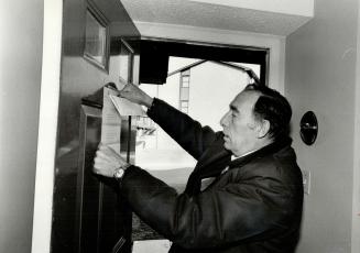 It's final: Sheriff's officer Ross Moore attaches the official notice to the door of a home whose owners were unable to keep to the mortgage payments