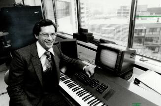Dual keyboards: Robert Moses, president of Syntronics, sits by one of the music processors he markets