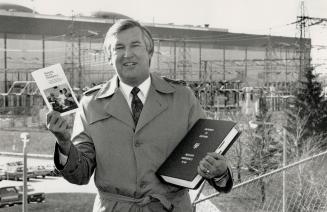 Muke Book: Jack Muir, corporate relations officer for Ontario Hydro at the Pickering nuclear station (in background), holds pamphlet distributed to citizens within 10 kilometres (603 miles) of the plant advising them how to respond to a nuclear emergency