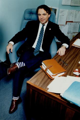 Footloose: Matey Nedkov de Lacamp wears a striking pair of blue and white striped socks to the office.