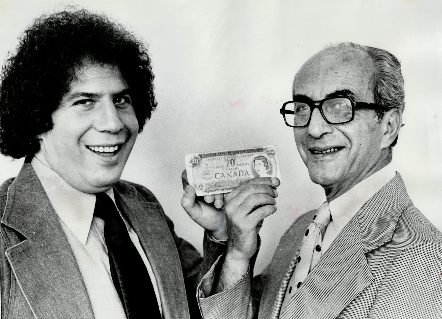 George Newman and his son, also George, hold a $20 bill, which is all they had when they came to Toronto from Hungary in 1956