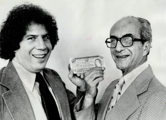 George Newman and his son, also George, hold a $20 bill, which is all they had when they came to Toronto from Hungary in 1956